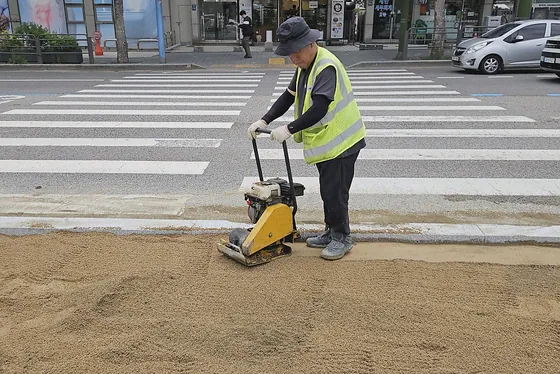 다짐기로 모래 바닥을 다지는 작업